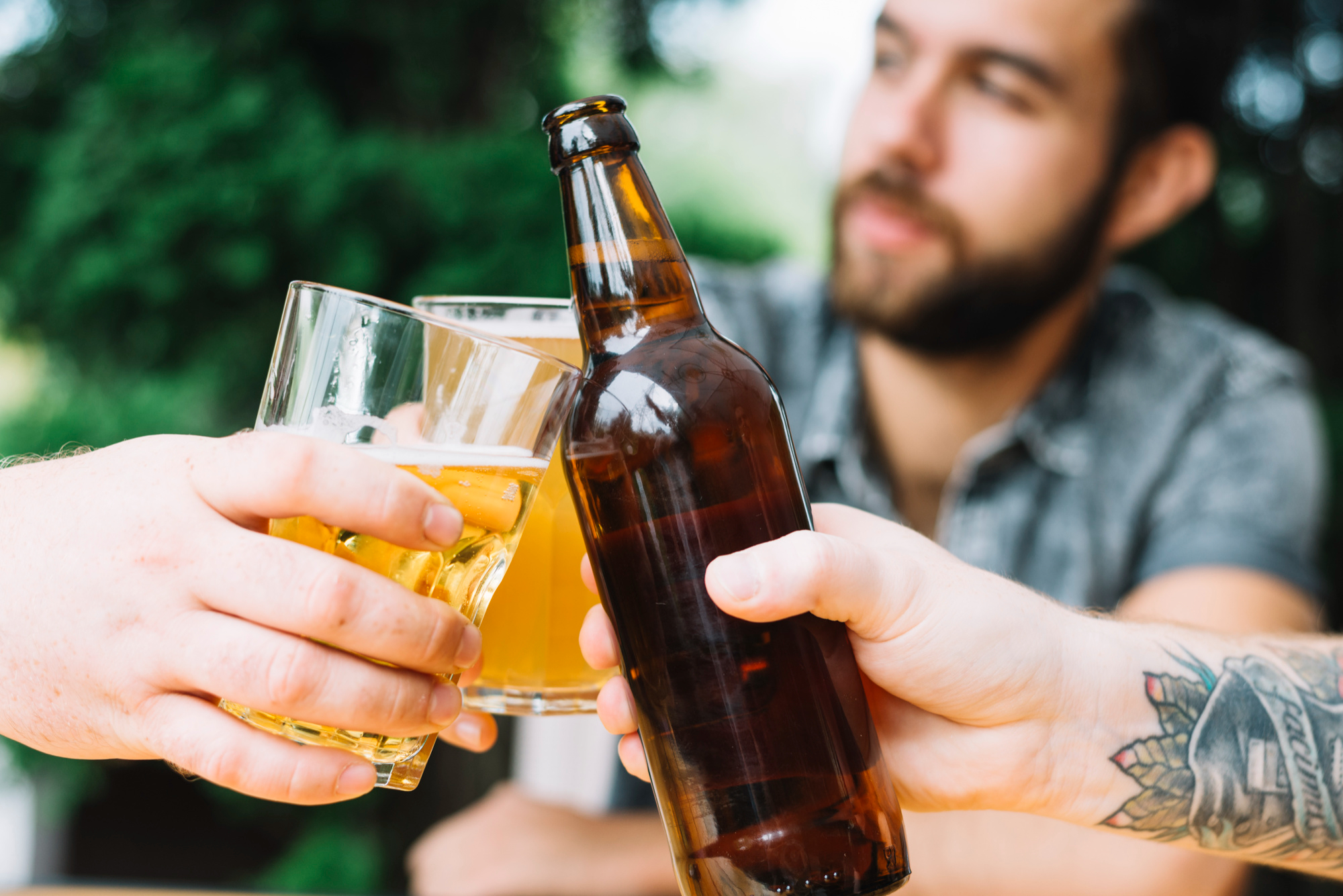 Two people raising bottles of beer together